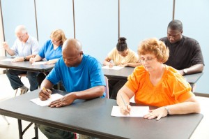 Diverse adult education class taking a test in the classroom.